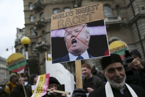 A demonstrator holds a placard of  U.S. presidential candidate Donald Trump during a refugees welcome march in London